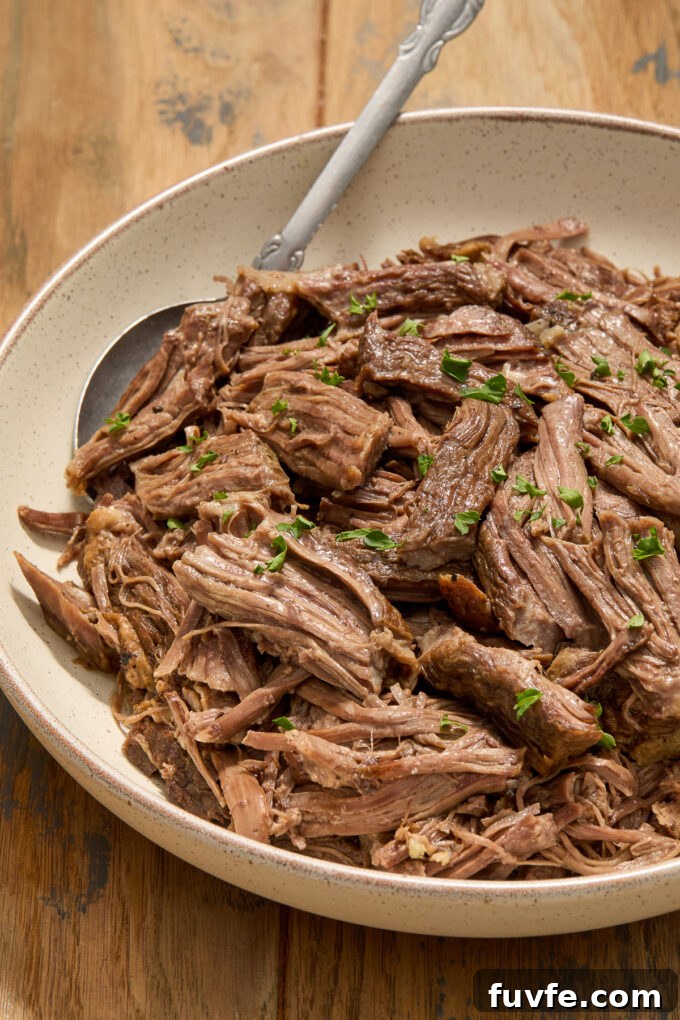 Red Wine Braised Beef Short Rib Risotto 8 Braised beef short ribs in a bowl with parsley.