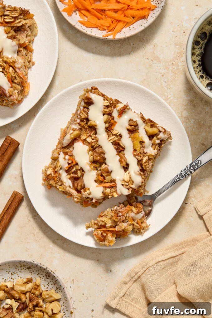 Slice of baked carrot oatmeal with cream cheese glaze on a plate.
