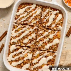 Carrot Cake Baked Oatmeal topped with cream cheese glaze in baking dish.