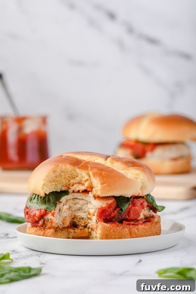 Ground chicken burger on a plate with a bite out of it