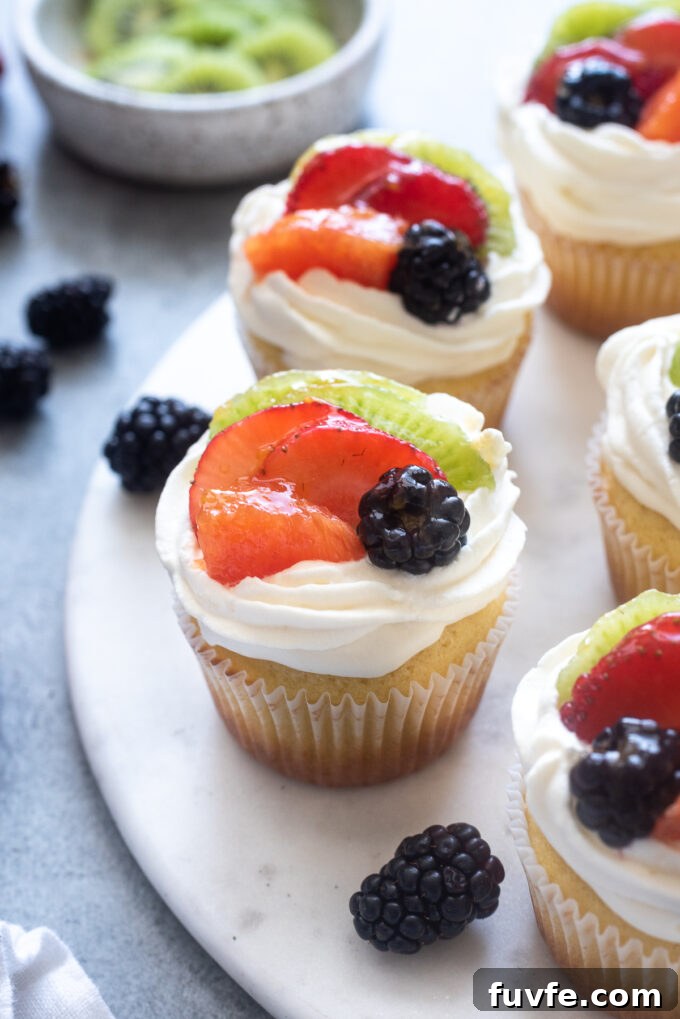 Fruit tart vanilla cupcakes on a serving board.