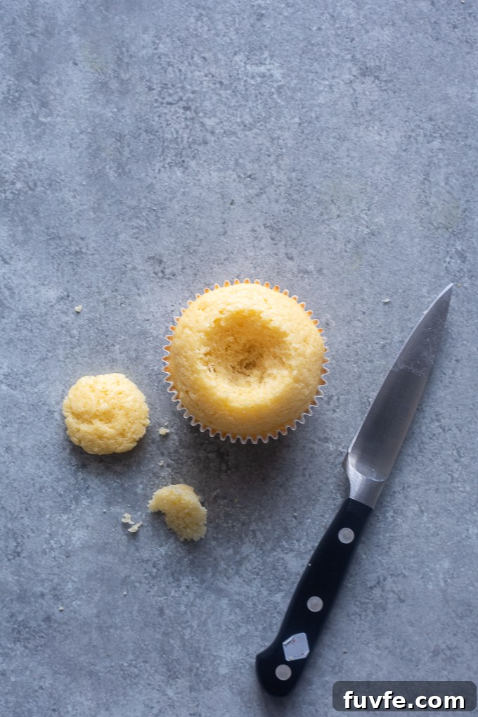 Vanilla cupcake with center cut out.