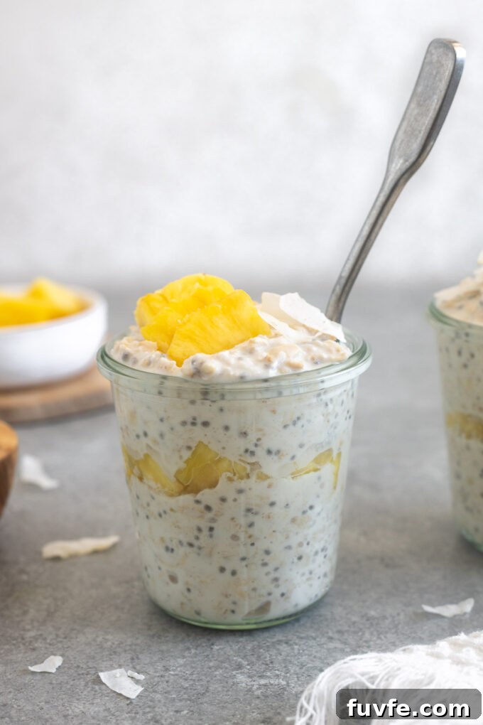 Pineapple overnight oats in a jar with a spoon.