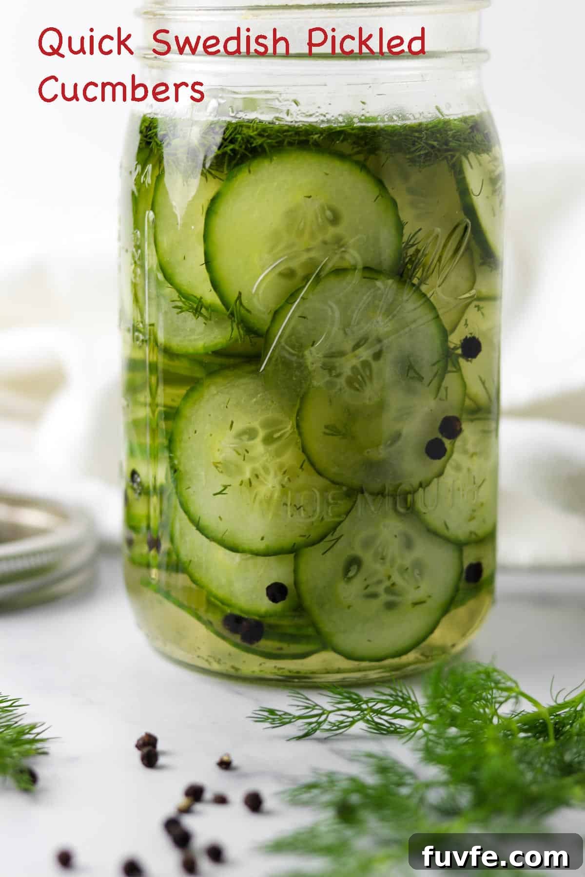 Swedish Meatballs with Classic Creamy Gravy (Köttbullar) 6 Quick Swedish Pickled Cucumbers in a jar next to peppercorns and fresh dill sprigs.