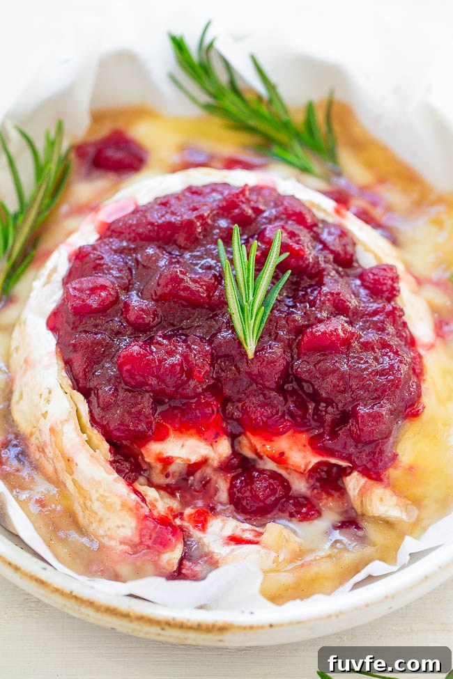 Cranberry Baked Brie topped with fresh rosemary. 