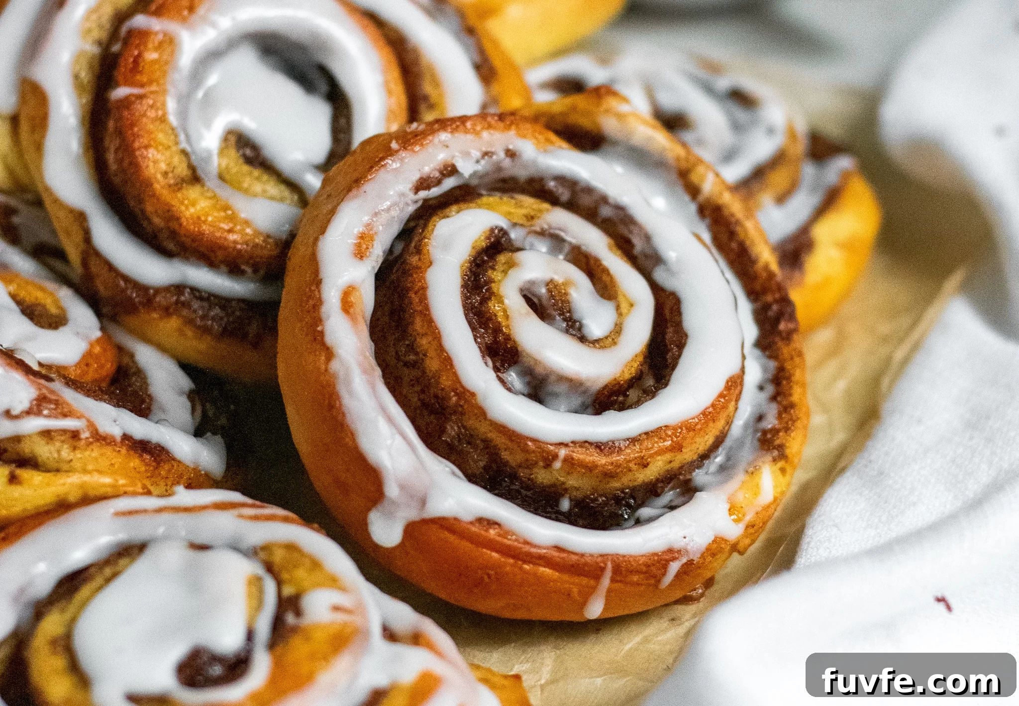 Cinnamon rolls on a piece of parchment paper.