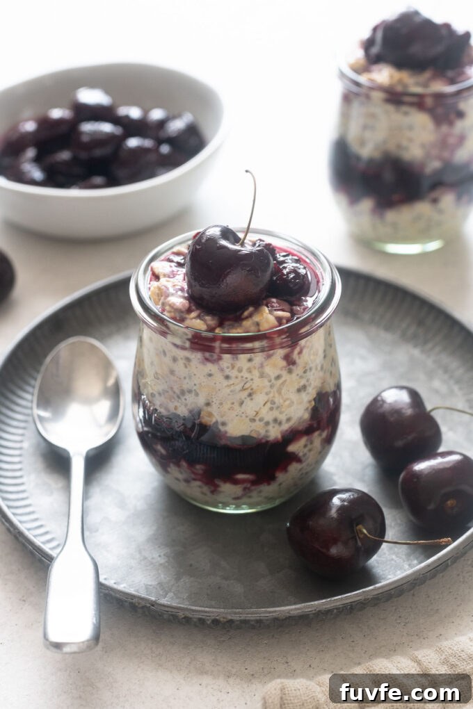 Cherry Pie Overnight Oats in a jar with cherries surrounding.