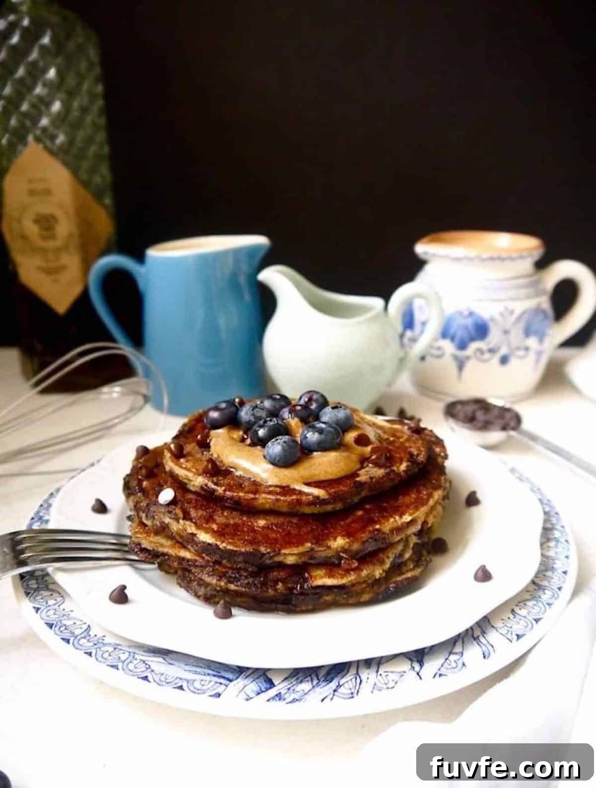 Paleo banana pancakes with blueberries and almond butter on top.