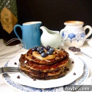 Paleo banana pancakes with blueberries and almond butter on top.