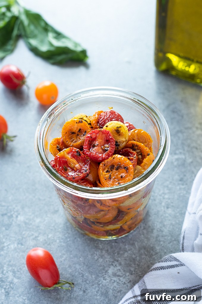 Slow roasted cherry tomatoes in a jar with linen alongside