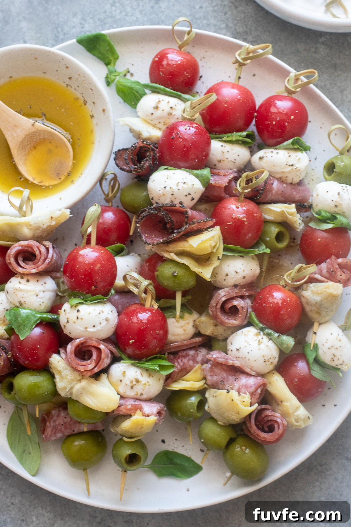 Mini Italian antipasto skewers drizzled with Italian dressing.
