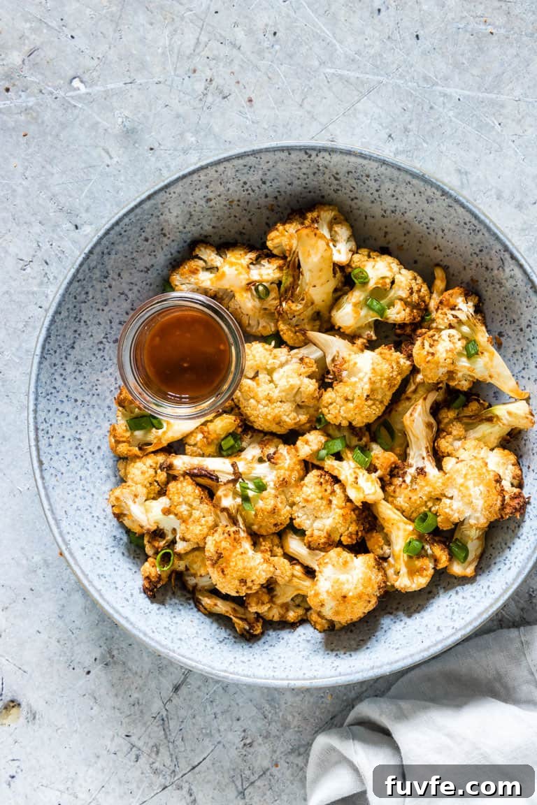 Air fryer buffalo cauliflower wings in a bowl with sauce