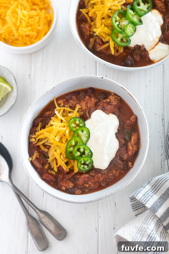 Bowl of slow cooker turkey chili loaded with cheese, sour cream and jalapenos
