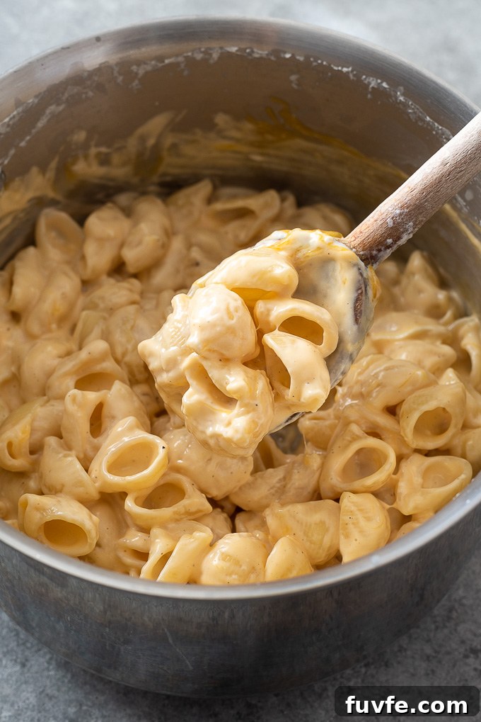 15-Minute Creamy Stovetop Mac and Cheese 7 Spoonful of creamy mac and cheese over a pot