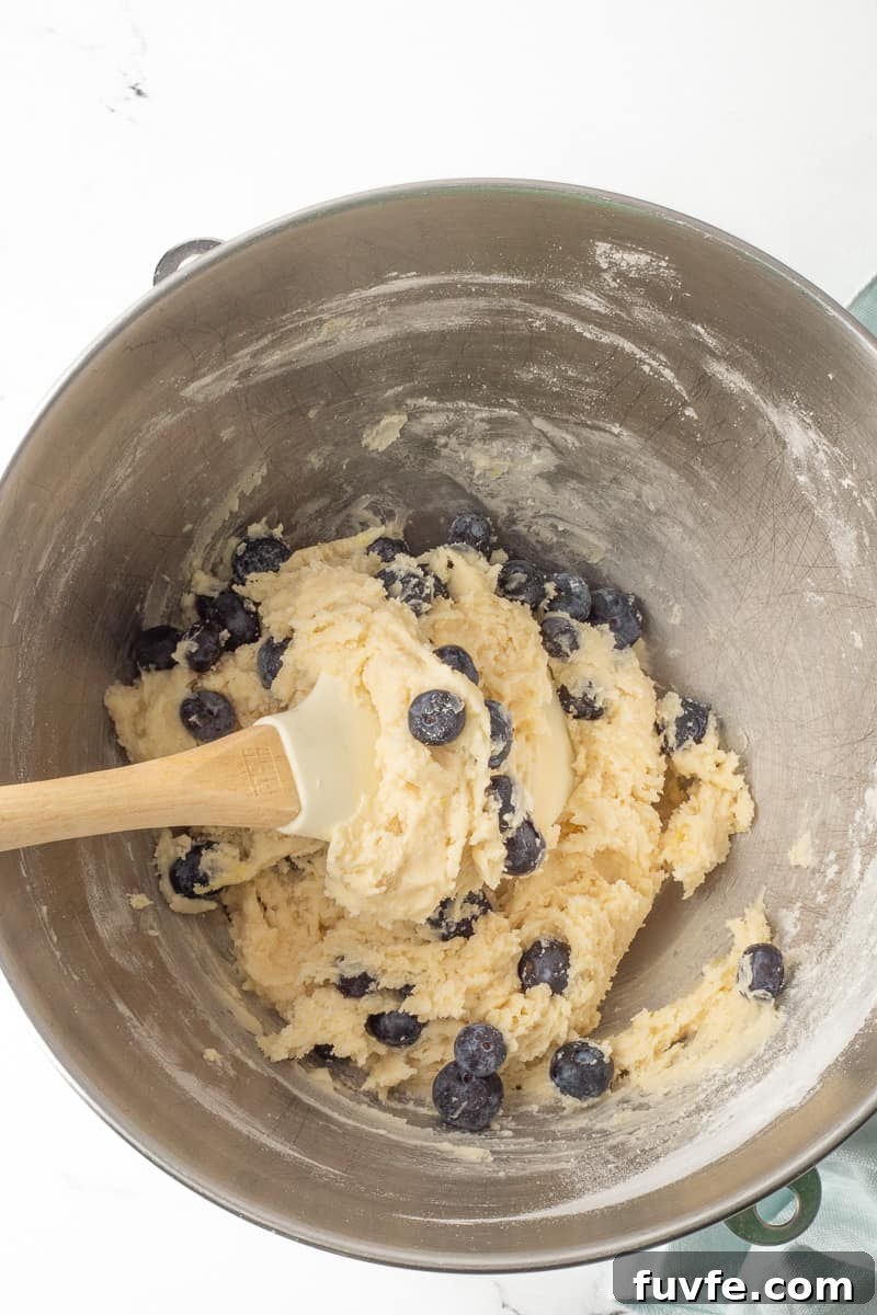 Soft Lemon Blueberry Cookies Recipe: Tender Citrus Berry Treats 7 Fresh blueberries are added to the cookie batter with a spatula.