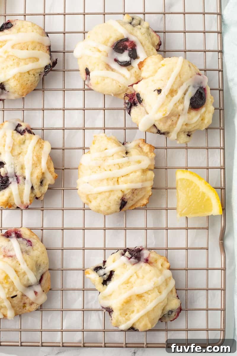 Soft Lemon Blueberry Cookies Recipe: Tender Citrus Berry Treats 8 Baked blueberry cookies with glaze on a wire cooling rack.