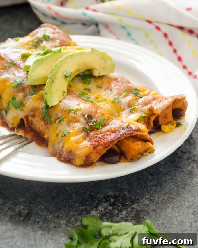 Sweet potato black bean enchiladas on a plate with avocado