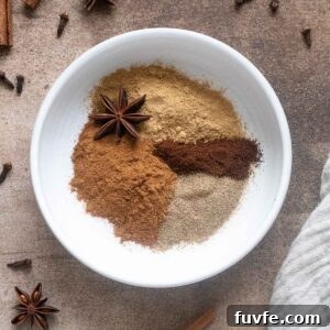 Spices for chai spice mix in a small white bowl.