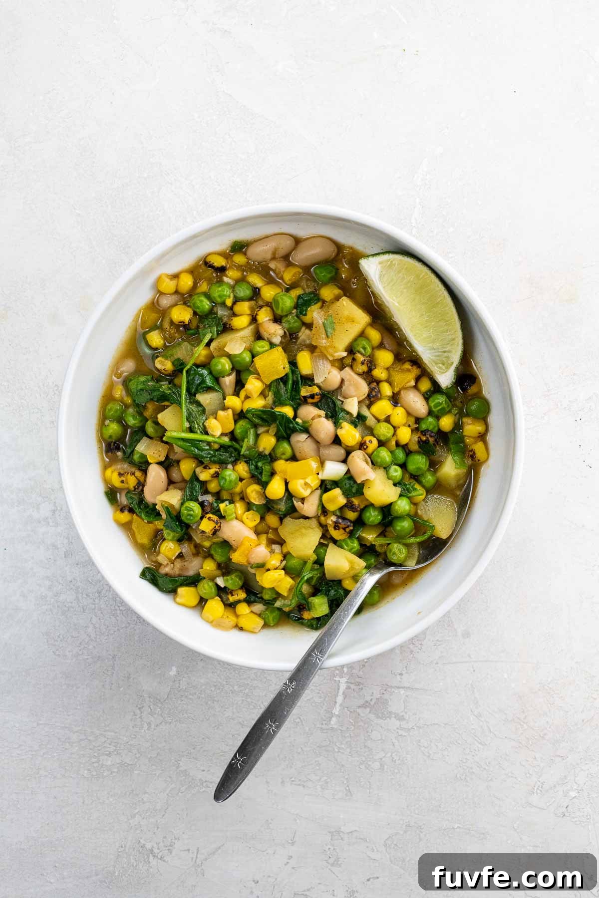 Hearty White Bean Stew with Potatoes and Sweet Corn 5 white bean stew with potatoes and corn in a white bowl with a spoon