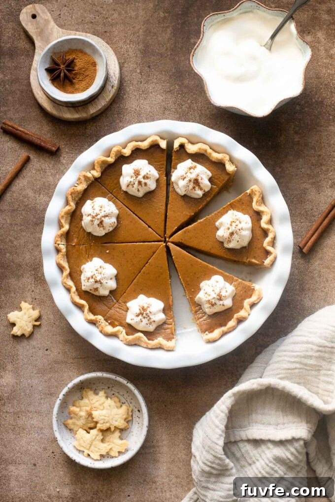 Maple Chai Pumpkin Pie cut in slices and topped with whipped cream.