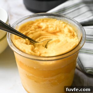 2-Ingredient Mango Sorbet Recipe for Ninja Creami Machines 13 a ninja creami pint container of mango sorbet, after spinning, with a spoon.