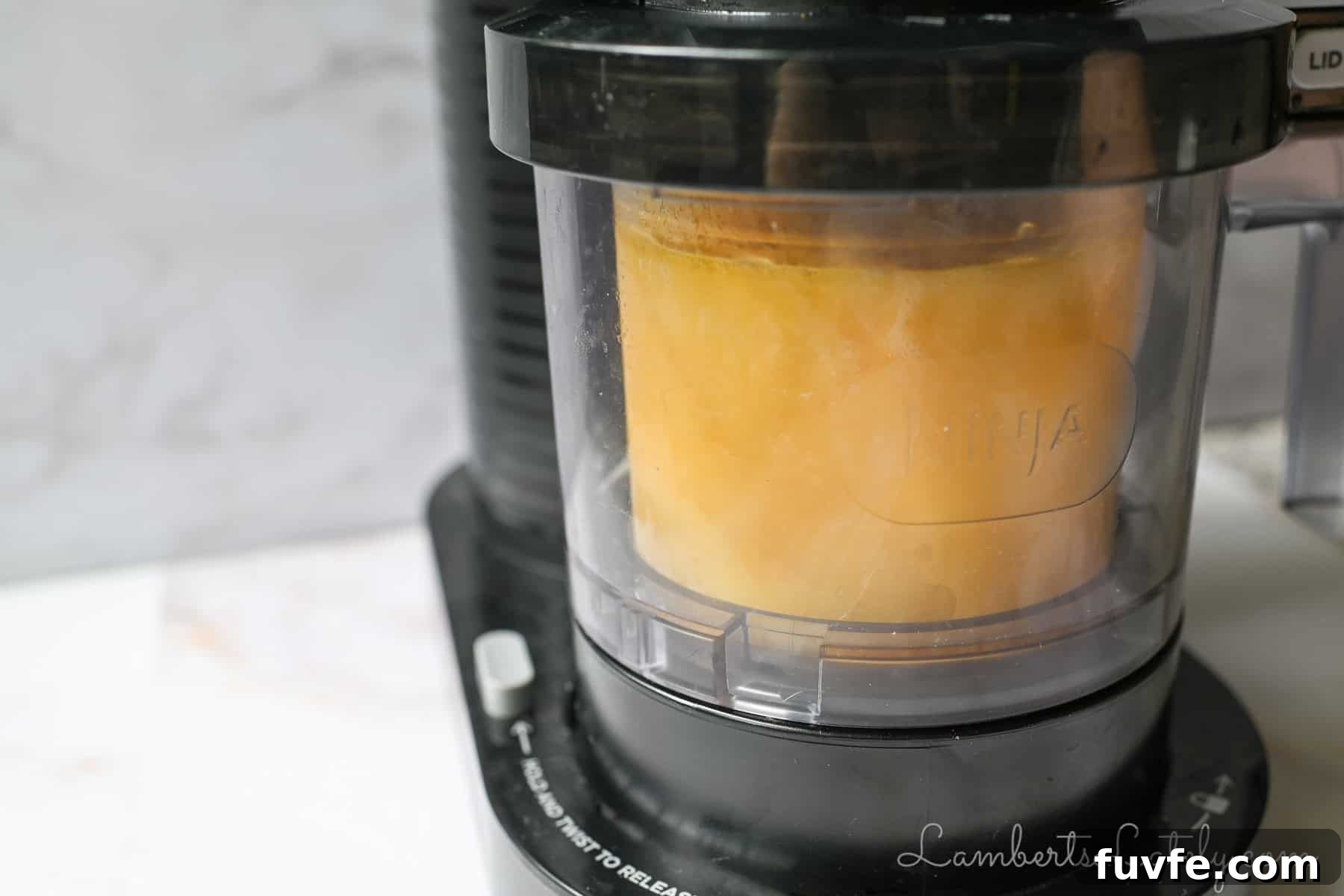 ninja-creami-mango-sorbet-4 mango sorbet going through the sorbet cycle in a ninja creami machine.