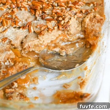 spoon in a dish of caramel apple dump cake.