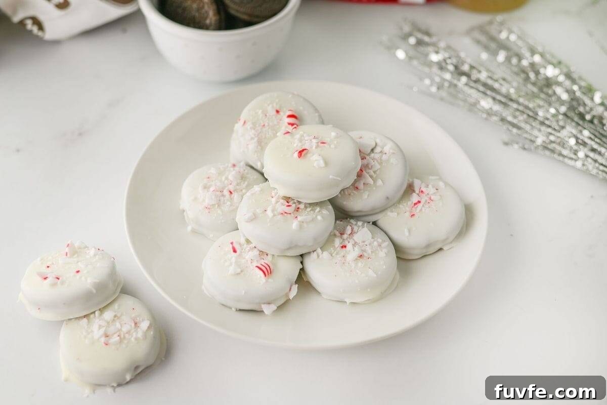 29 Christmas Baking Ideas for Home Bakers Who Love a Busy Oven 11 A white plate of Peppermint Crunch Oreos topped with crushed peppermint pieces sits on a white surface.