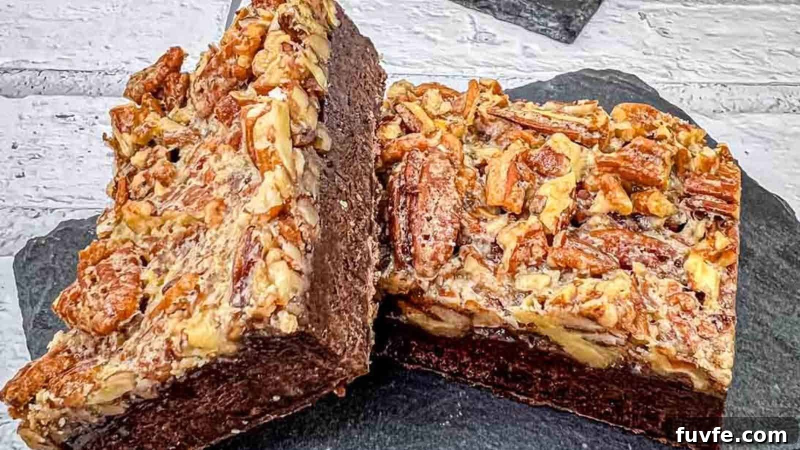 29 Christmas Baking Ideas for Home Bakers Who Love a Busy Oven 17 A close-up of two pecan brownies on a slate surface, showing the rich, chocolatey interior and a topping of chopped pecans.