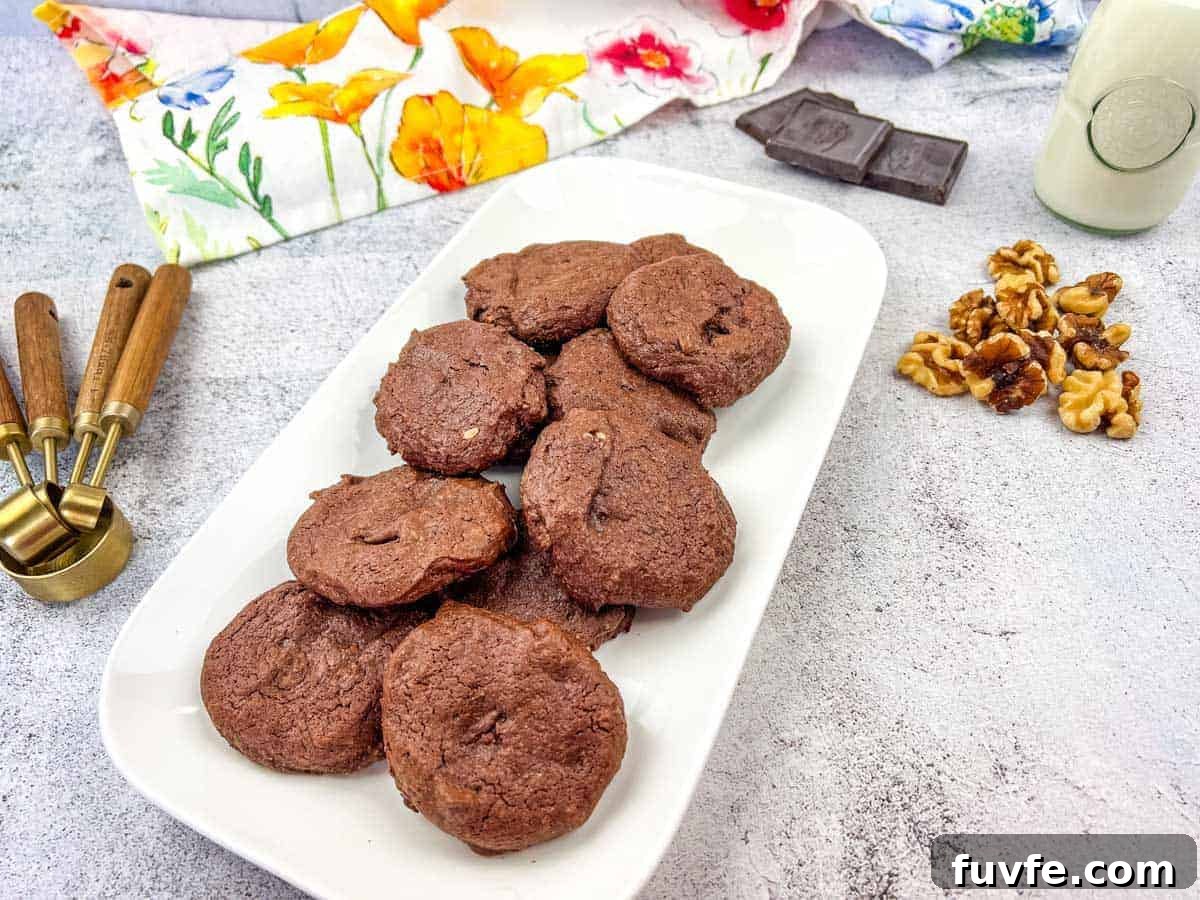 29 Christmas Baking Ideas for Home Bakers Who Love a Busy Oven 20 A plate of chocolate cookies with walnuts and chocolate pieces on the side.