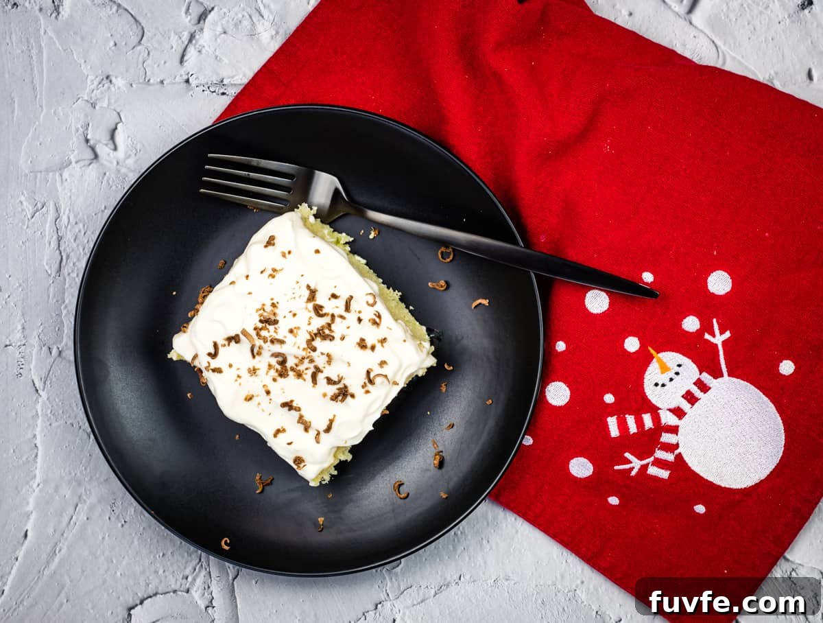 29 Christmas Baking Ideas for Home Bakers Who Love a Busy Oven 21 A piece of eggnog tres leches cake on a black plate with a fork.