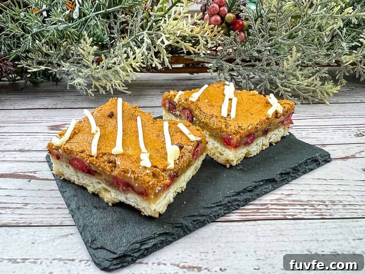 29 Christmas Baking Ideas for Home Bakers Who Love a Busy Oven 23 Two squares of cranberry bars on a slate plate.