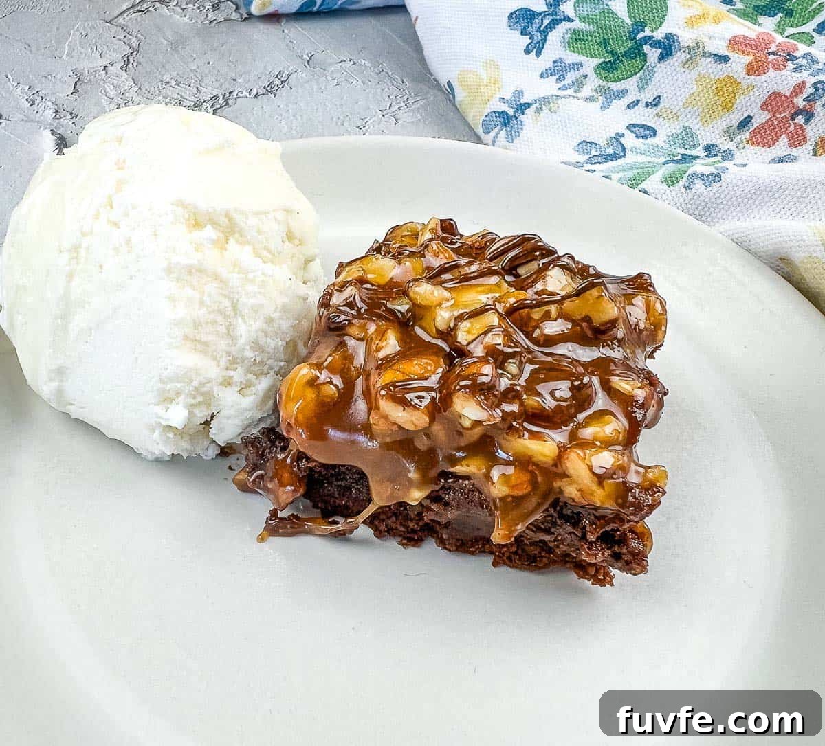 29 Christmas Baking Ideas for Home Bakers Who Love a Busy Oven 25 A piece of Turtle Brownie with ice cream on a plate.