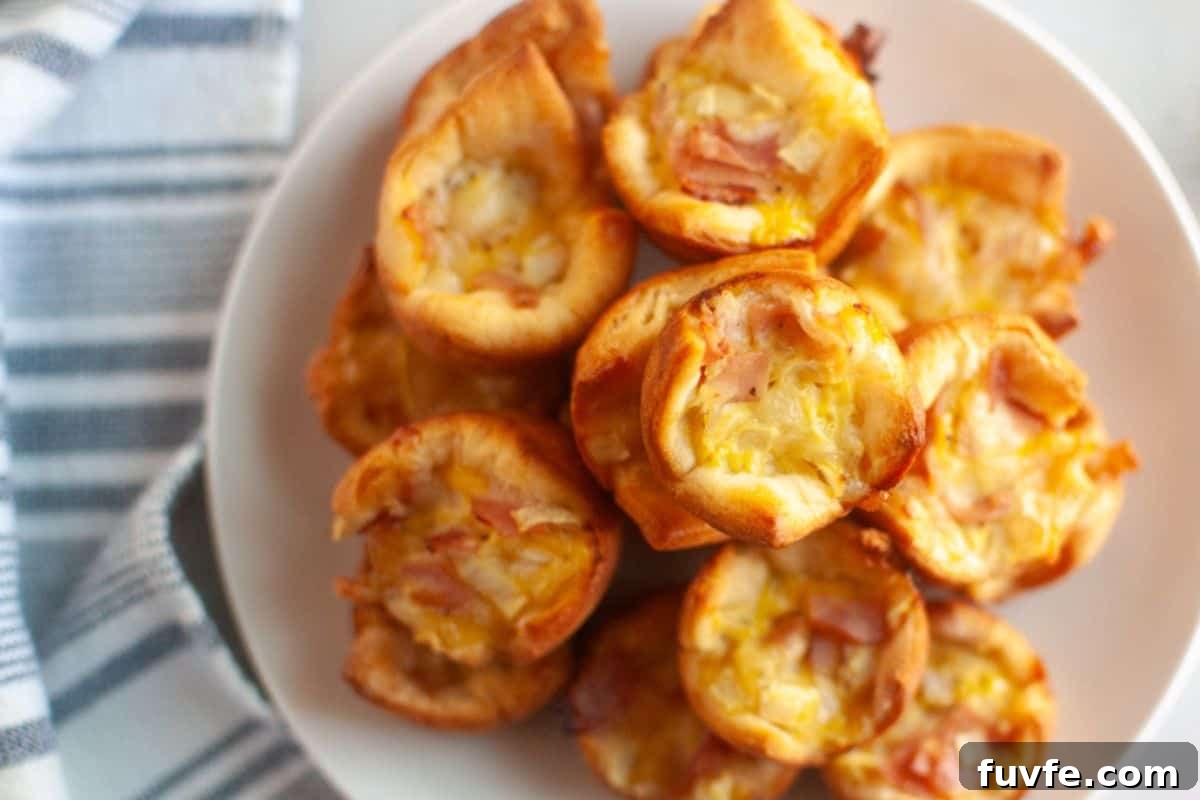 29 Christmas Baking Ideas for Home Bakers Who Love a Busy Oven 29 Overhead close-up of a white plate filled with small, golden-brown Ham & Cheese Puffs.