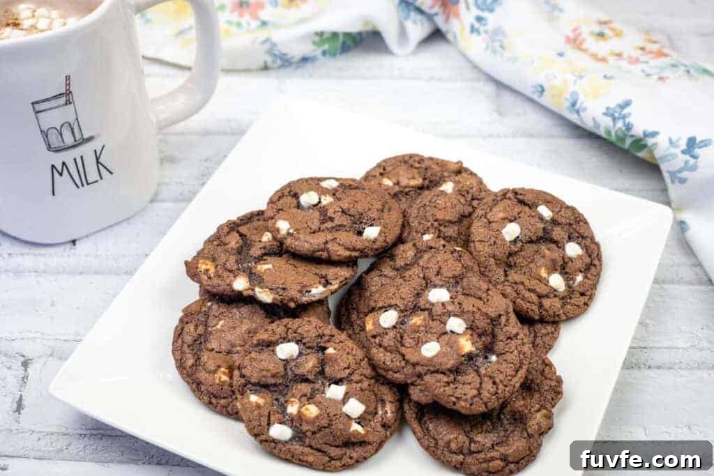 29 Christmas Baking Ideas for Home Bakers Who Love a Busy Oven 9 A white square plate with a stack of chocolate cookies featuring white chocolate chips.