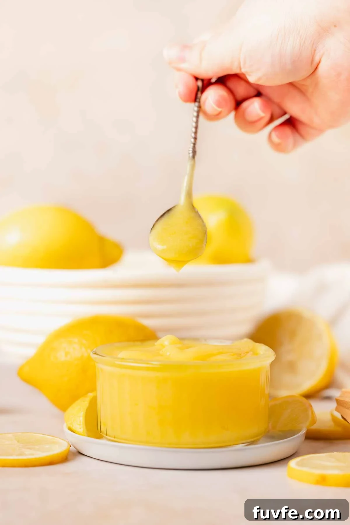 Homemade Lemon Curd Recipe: Smooth, Tangy, and Spreadable 2 hand holding spoon with lemon curd