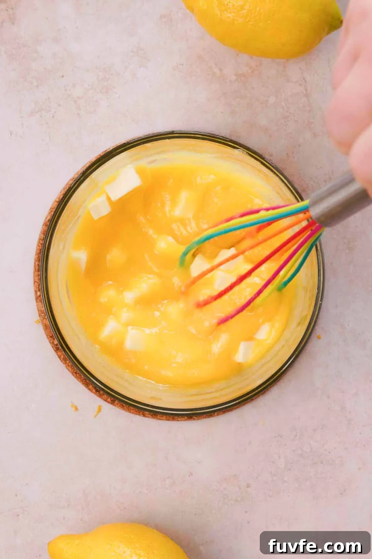 Homemade Lemon Curd Recipe: Smooth, Tangy, and Spreadable 7 whisking cooked lemon curd in glass bowl with cold butter