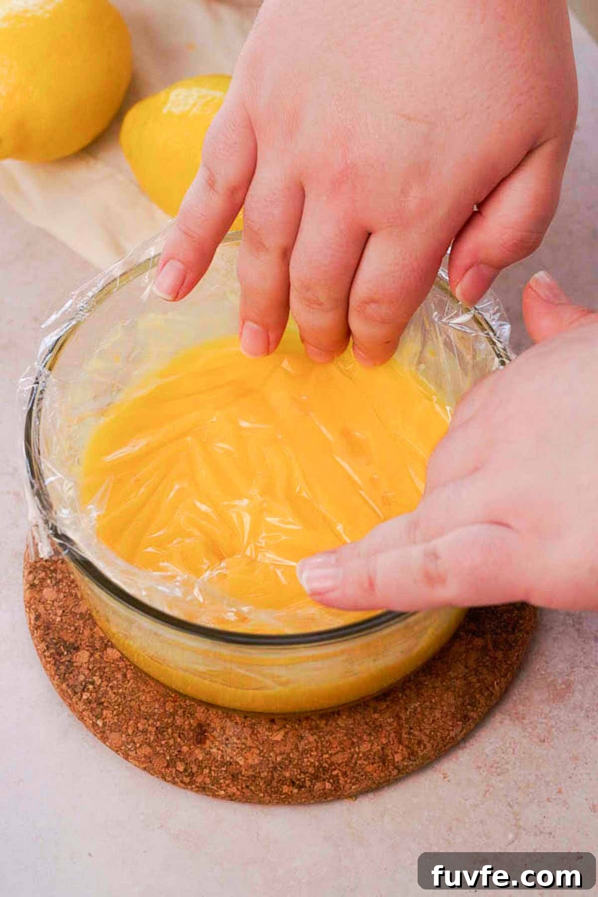Homemade Lemon Curd Recipe: Smooth, Tangy, and Spreadable 8 covering lemon curd in bowl with plastic wrap