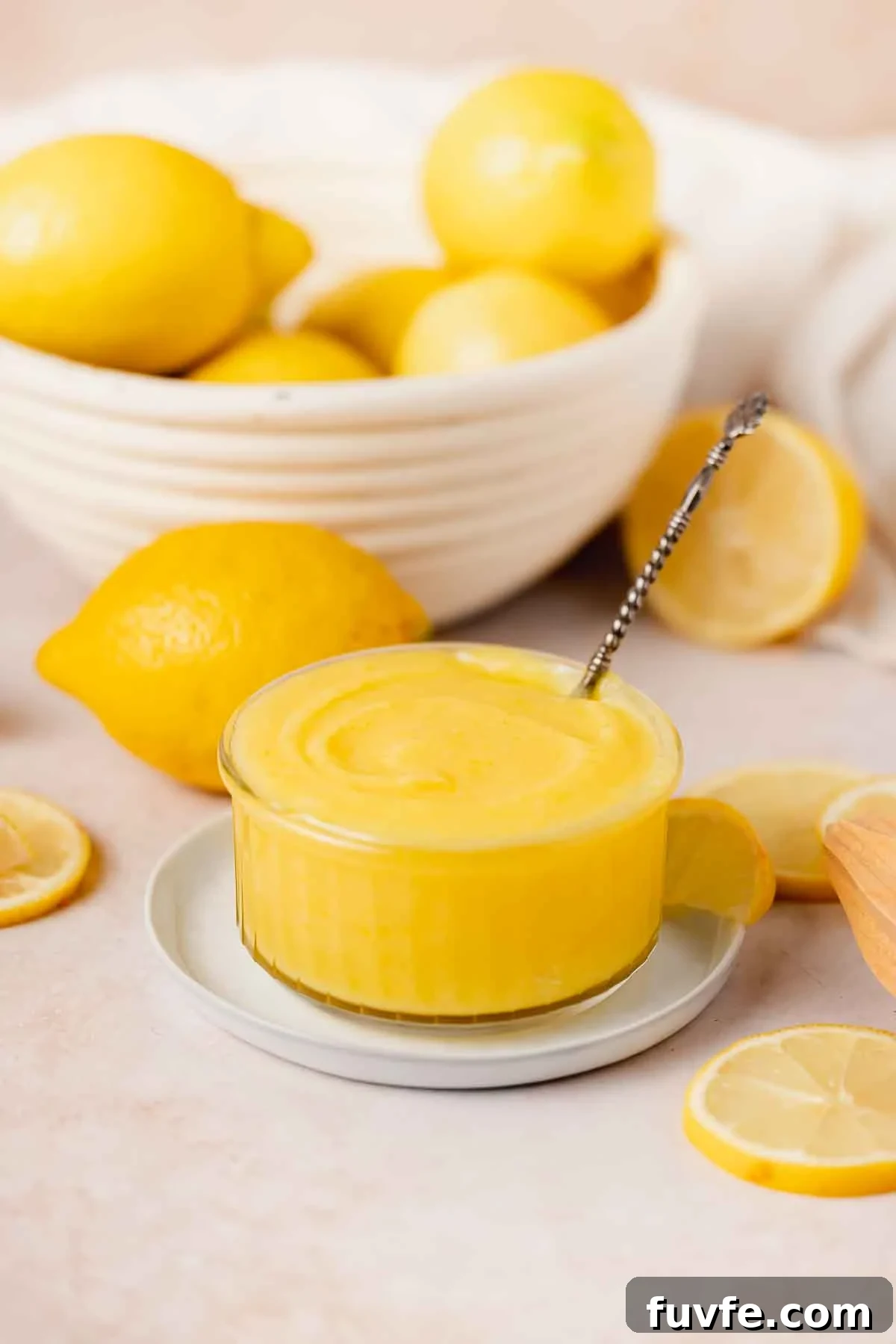 Homemade Lemon Curd Recipe: Smooth, Tangy, and Spreadable 9 lemon curd in bowl with silver spoon