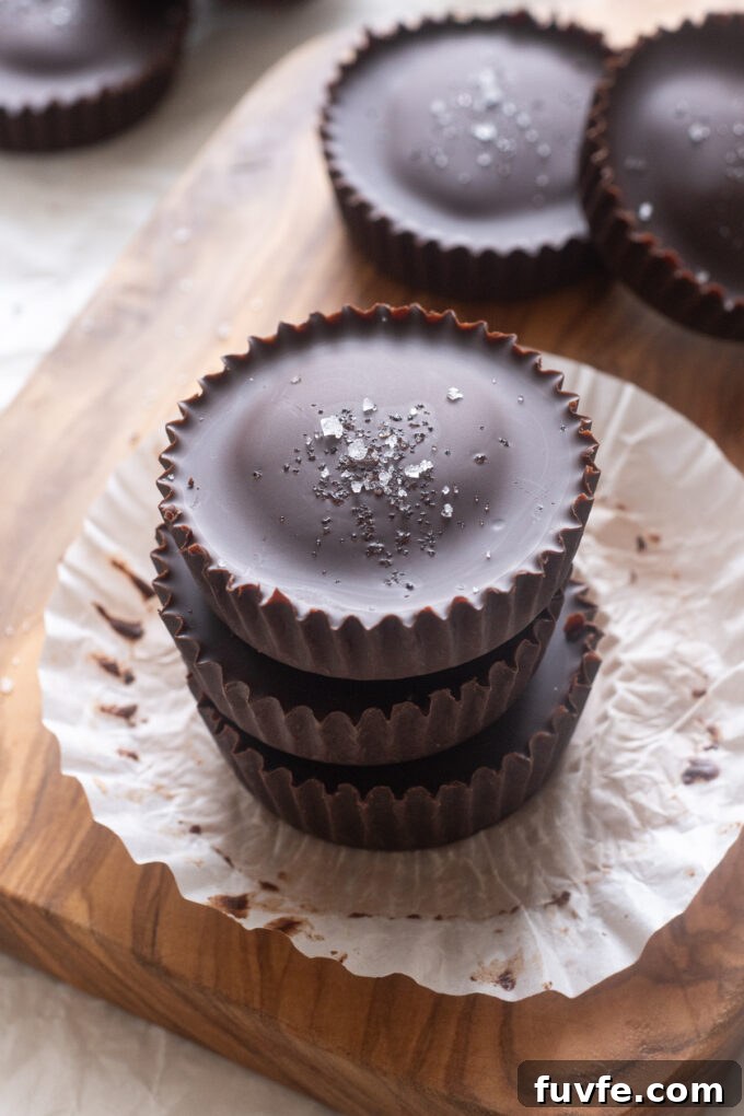 Homemade Protein Peanut Butter Cups 3 Overhead shot of homemade protein peanut butter cups topped with flaky sea salt on paper liner.