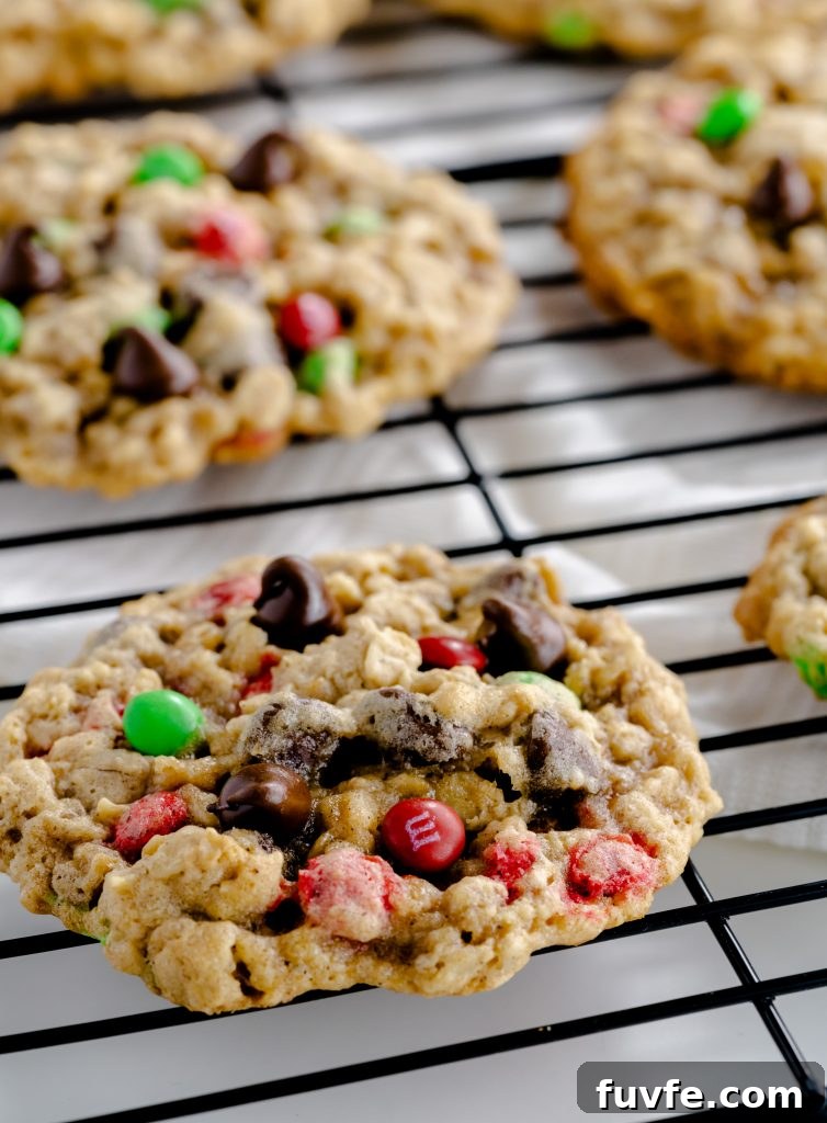 Close up of cookie made with oatmeal, chocolate chips, and red and green M&M's.
