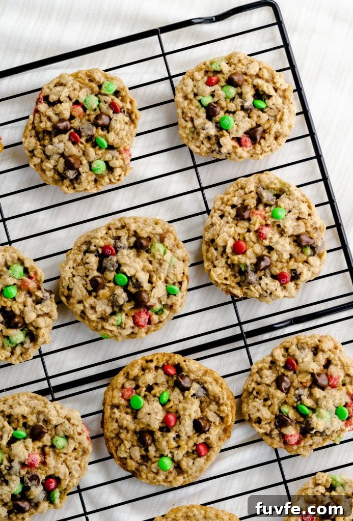 Chewy chocolate chip M&M oatmeal cookies cooling on rack.