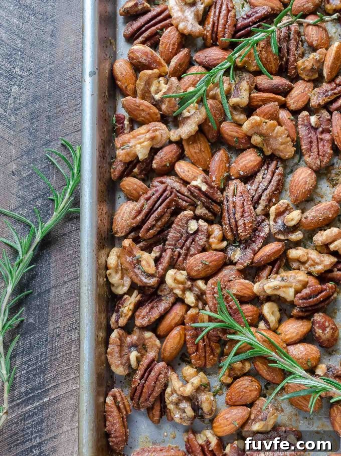 Roasted nuts on a sheet pan with rosemary