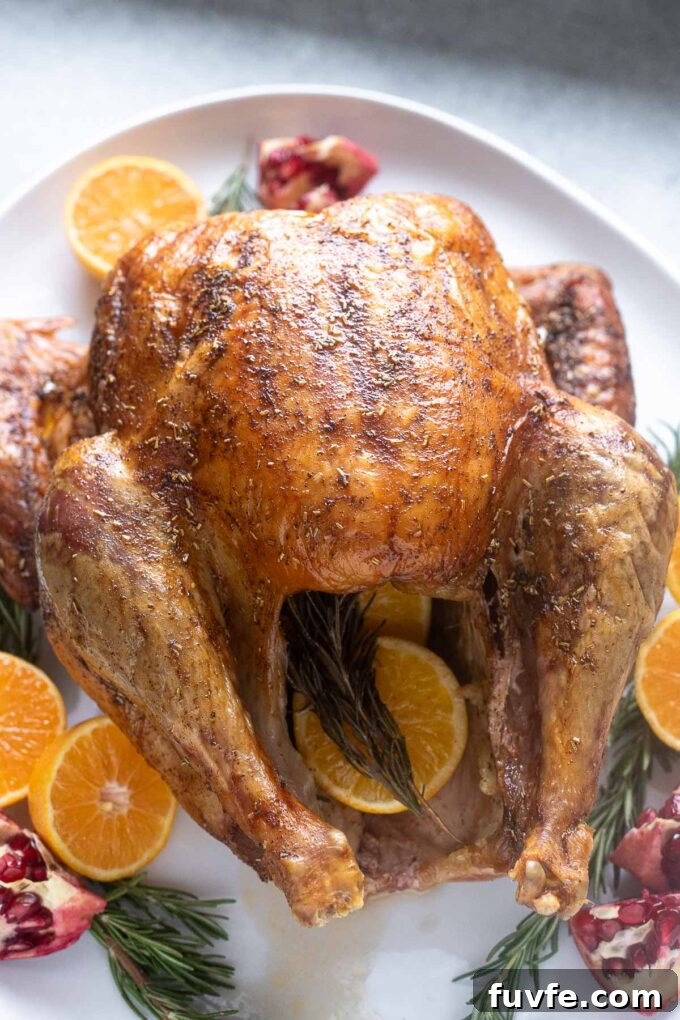 Dry-Brined Roast Turkey Recipe for Juicy, Crispy Skin 2 Dry brine turkey on a platter with orange and rosemary.