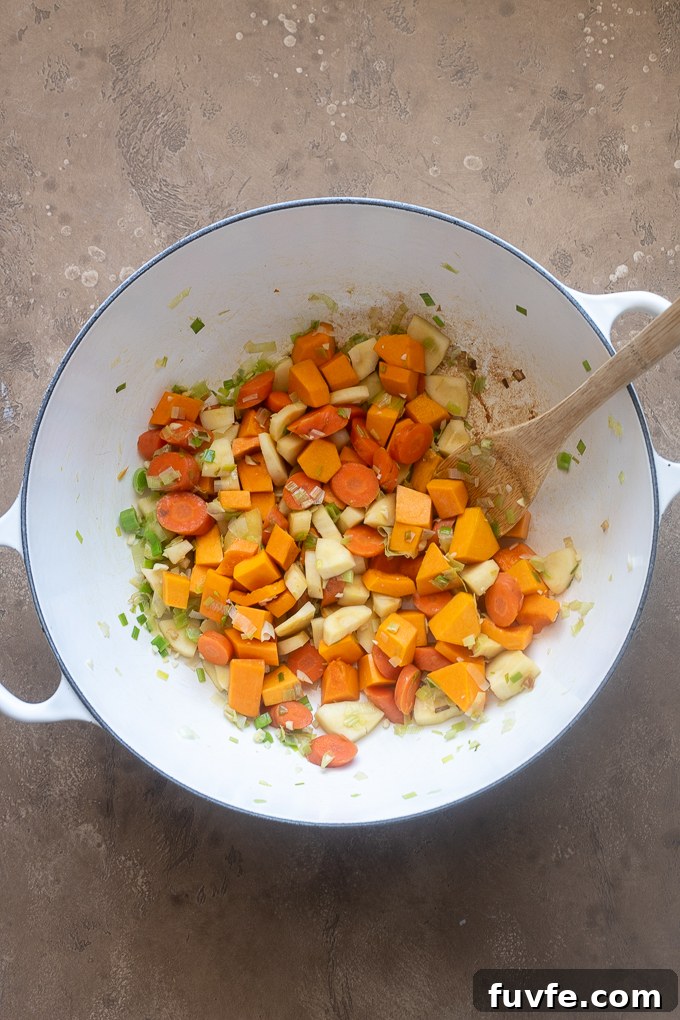 Comforting Autumn Vegetable Soup with Roasted Roots 4 Leeks, carrots, parsnips and garlic sautéed for fall vegetable soup.