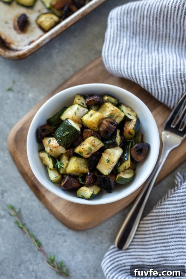 Garlic-Roasted Zucchini and Mushrooms Recipe 4 Overhead shot of roasted zucchini and mushrooms in a white bowl