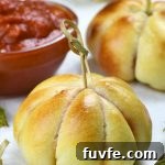 Pepperoni Pizza Pumpkin Recipe: Savory Stuffed Jack-O’-Lanterns 6 Two pepperoni pizza pumpkins with a bowl of marinara sauce