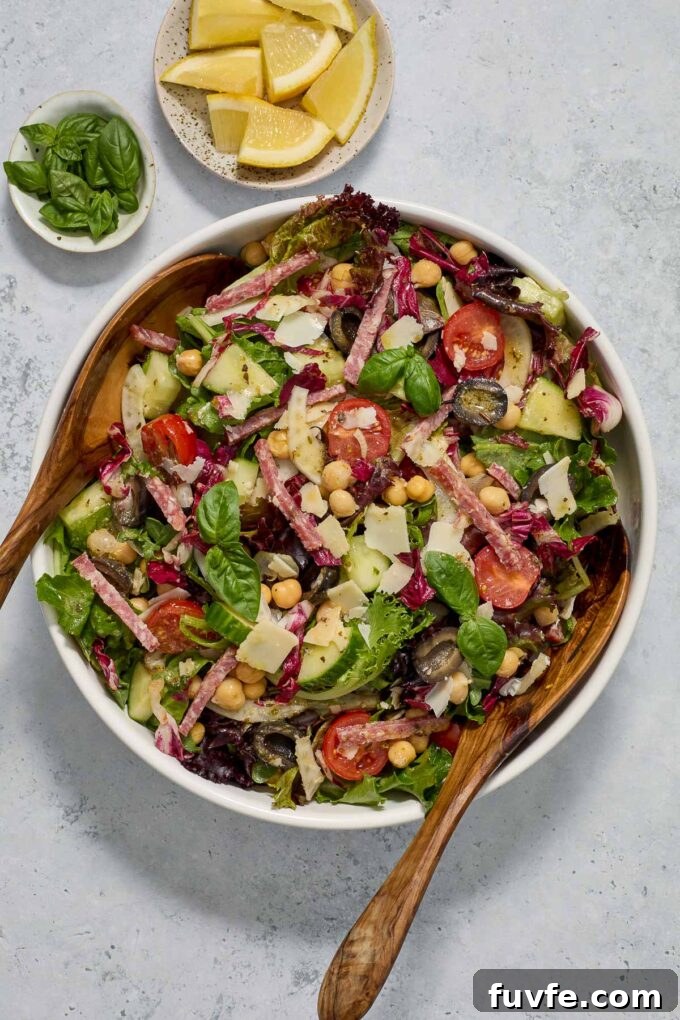 Classic Italian Chopped Salad Recipe with Zesty Vinaigrette 5 Italian chopped salad in a bowl with wooden servers.