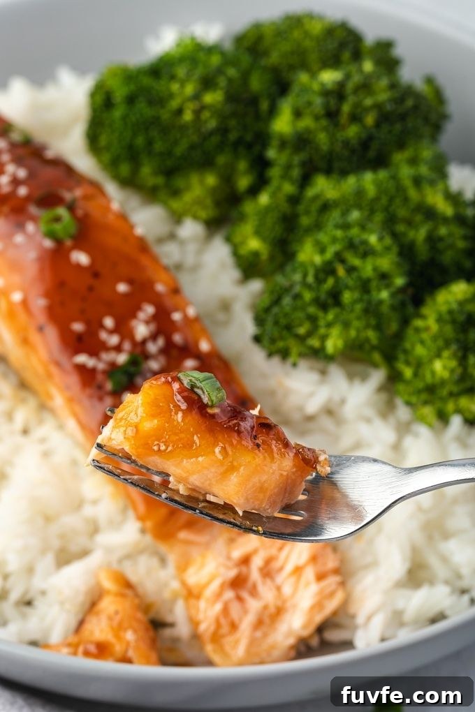 Crispy Oven-Baked Teriyaki Salmon Recipe with Sticky Glaze 7 Fork digging into plate of teriyaki salmon