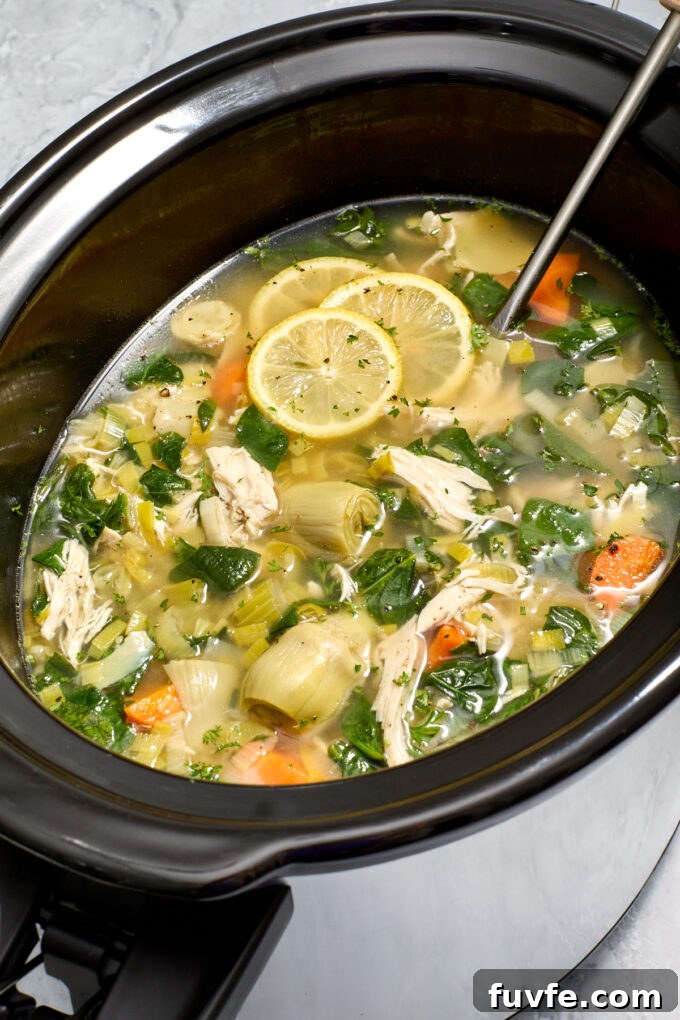 Lemon chicken soup with artichokes in slow cooker.